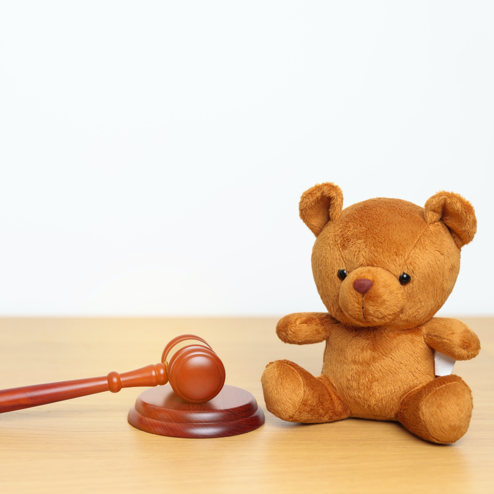 Children, Kid and Family Law concepts. toy bear with gavel justice hammer on desk in courthouse.